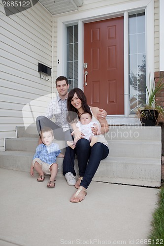 Image of Family Portrait Sitting In Front Of Their House