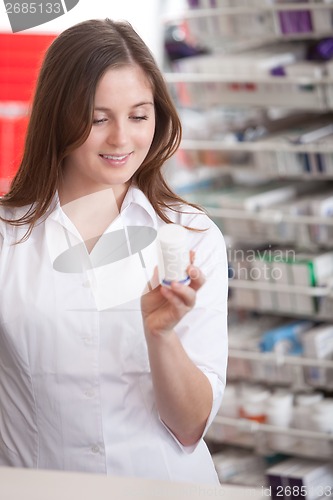 Image of Female Pharmacist Reading Information On Medicine