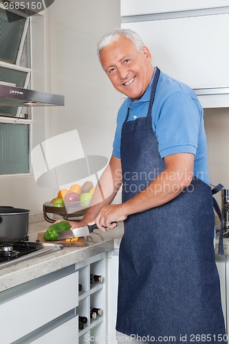 Image of Senior Man Cutting Vegetables