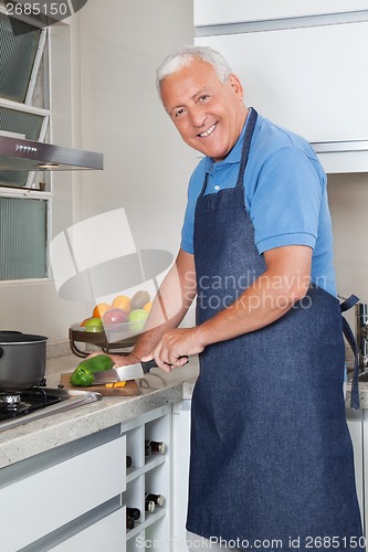 Image of Senior Man Cutting Vegetables