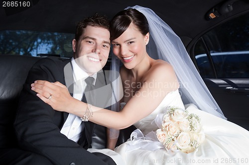 Image of Happy Wedding Couple in Limo