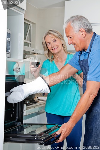 Image of Man Baking Food in Oven