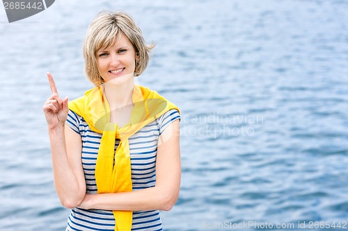 Image of Middle age woman outdoors with finger up