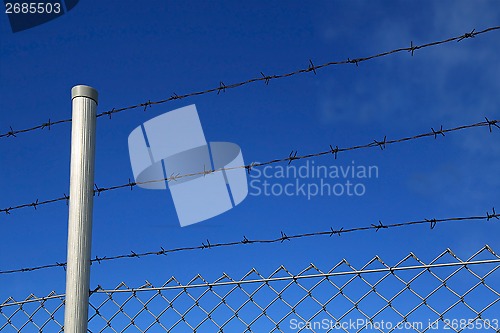 Image of Barbed Wire Fence Against Blue Sky