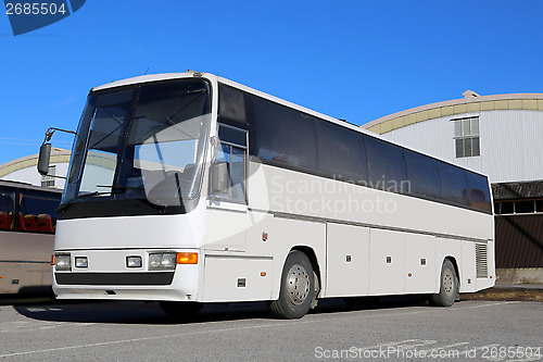 Image of White Coach Bus on a Bus Stop