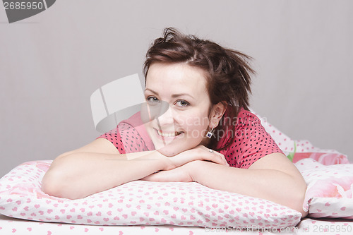 Image of Young girl smiling lying in bed