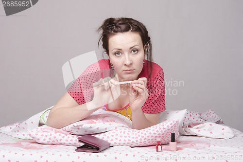Image of Girl ? bed engaged in manicure