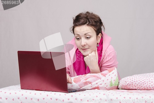 Image of Girl in bed with interest works for laptop