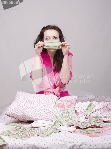 Image of Girl sitting on the bed rejoices money