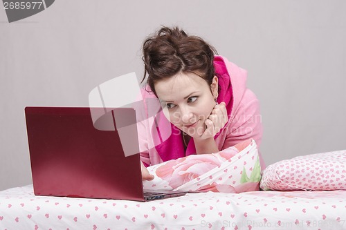 Image of Girl in bed playing with the laptop