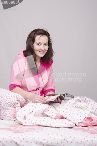 Image of Girl in bed with magazine