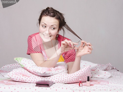 Image of Girl cutting a lock of hair cuticle scissors