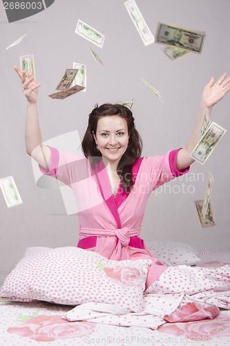 Image of The girl on bed falling banknotes