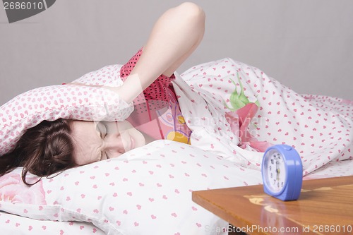 Image of Girl wakes up the clock in morning