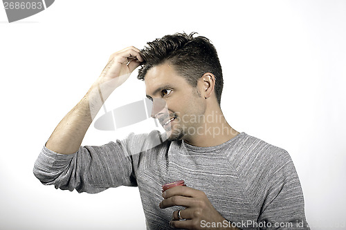 Image of A male applying hair style product