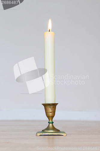 Image of Burning candle on wooden table