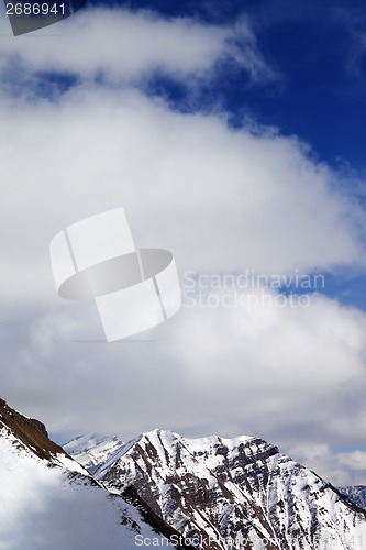 Image of Winter snowy mountains and sky with clouds at sun day