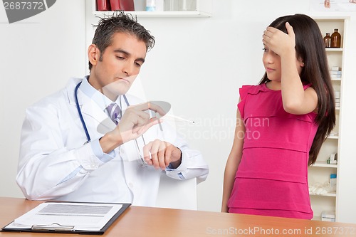 Image of Doctor Measuring Temperature of Girl