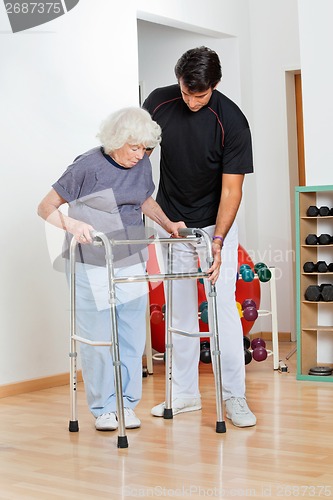 Image of Trainer Assisting Senior Woman In Moving