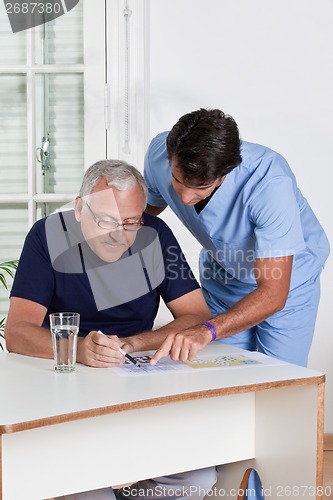 Image of Mature Man playing Sudoku Puzzle