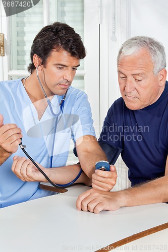 Image of Male Nurse Checking Blood Pressure Of a Senior Man