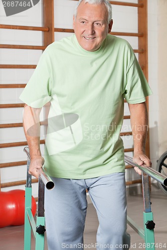 Image of Man Walking With The Help Of Support Bars