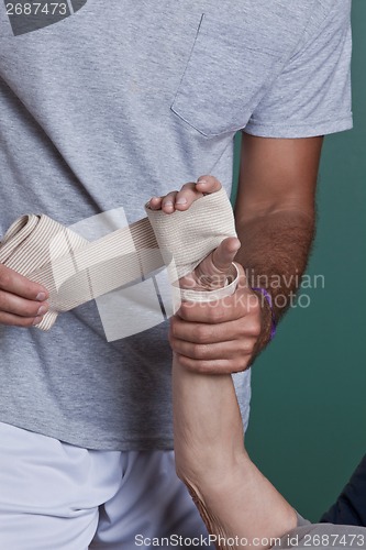 Image of Therapist applying Bandage on the Hand