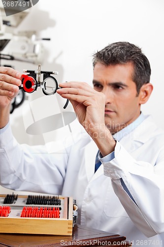 Image of Eye Doctor Checking Lens Of Trial Frames