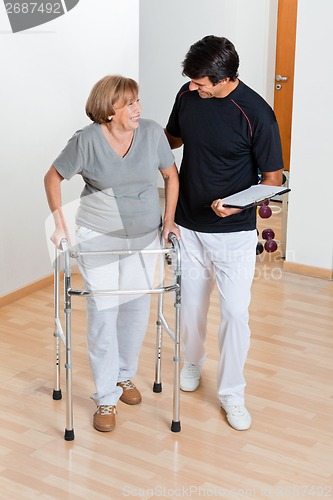 Image of Trainer Looking At Senior Woman Using Walker