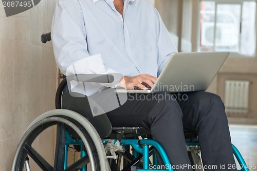 Image of Man Sitting In Wheel Chair Using Laptop