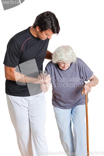 Image of Trainer Assisting Senior Woman Holding Walking Stick