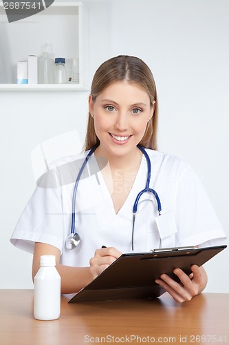 Image of Doctor Writing on Clipboard