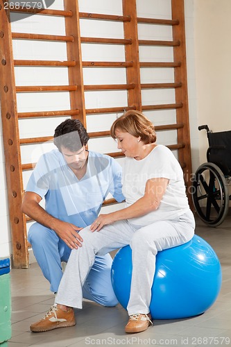 Image of Therapist Examining Senior Woman's Knee