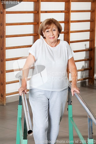 Image of Woman Walking With The Help Of Support Bars