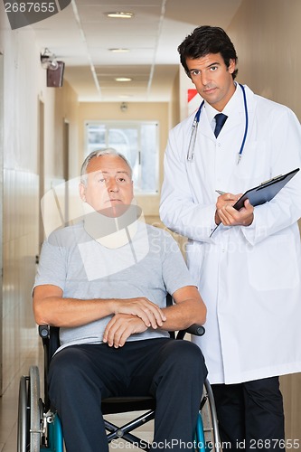 Image of Doctor Standing By Patient On Wheel Chair