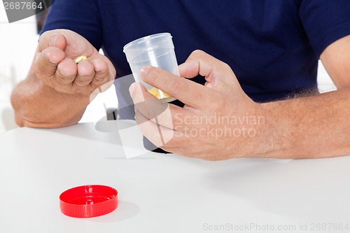 Image of Senior Man Holding Pills And Bottle