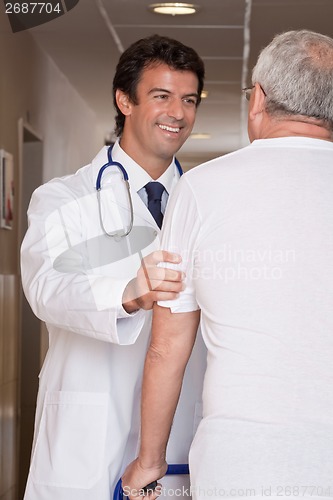 Image of Doctor helping Patient use Walker