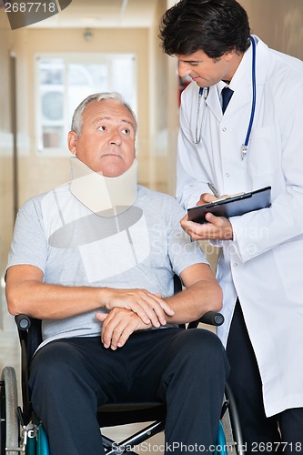 Image of Doctor Communicating With Patient On Wheel Chair