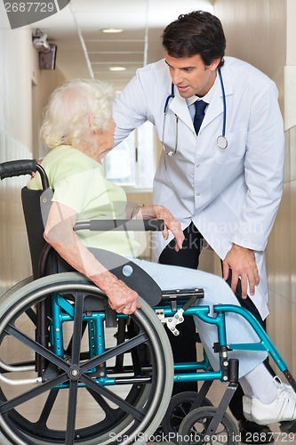 Image of Doctor Communicating With Senior Woman Sitting In Wheelchair