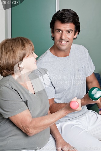 Image of Young instructor and Woman Exercising