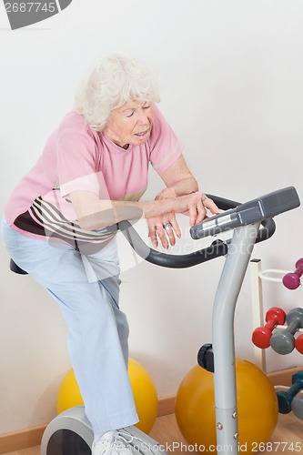 Image of Tired Senior Woman Exercising On Bike