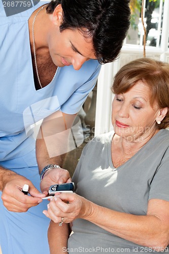 Image of Male Nurse Measuring Glucose Level