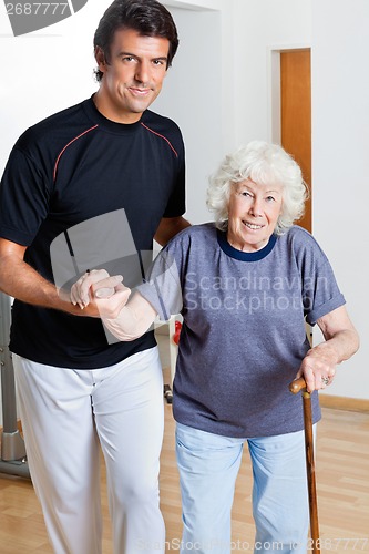 Image of Trainer Assisting Woman With Walking Stick
