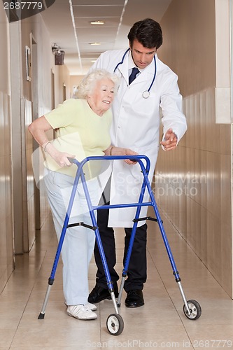 Image of Doctor helping Patient use Walker