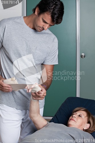 Image of Therapist applying Bandage on the Hand