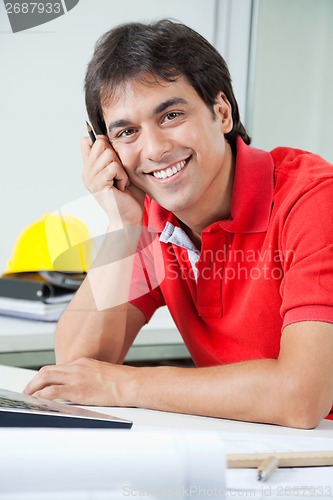 Image of Happy Architect Sitting By Desk