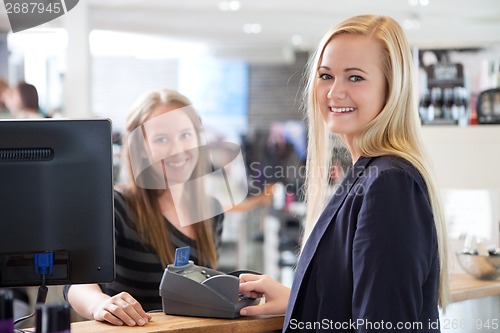 Image of Young woman paying at beauty salon