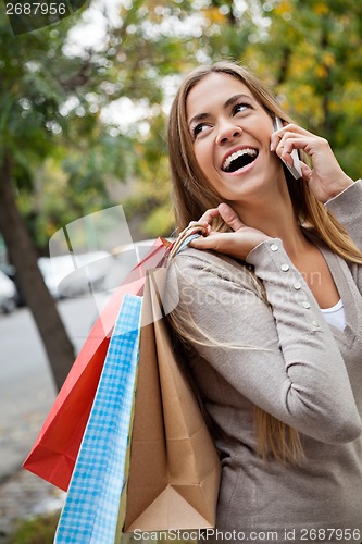 Image of Woman On A Call While Carrying Shopping Bags