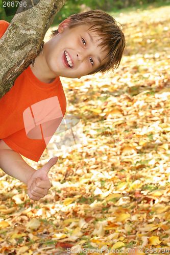 Image of Happy child plays in fall autumn leaves