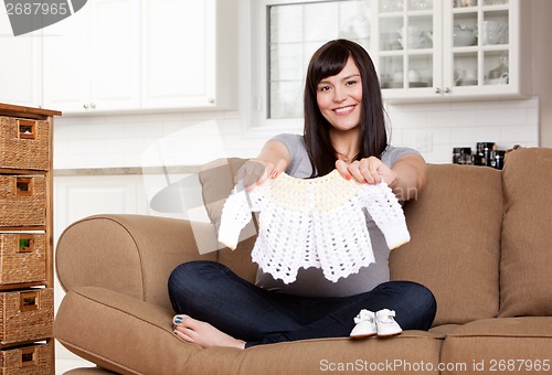 Image of Expecting Mother with Baby Clothes